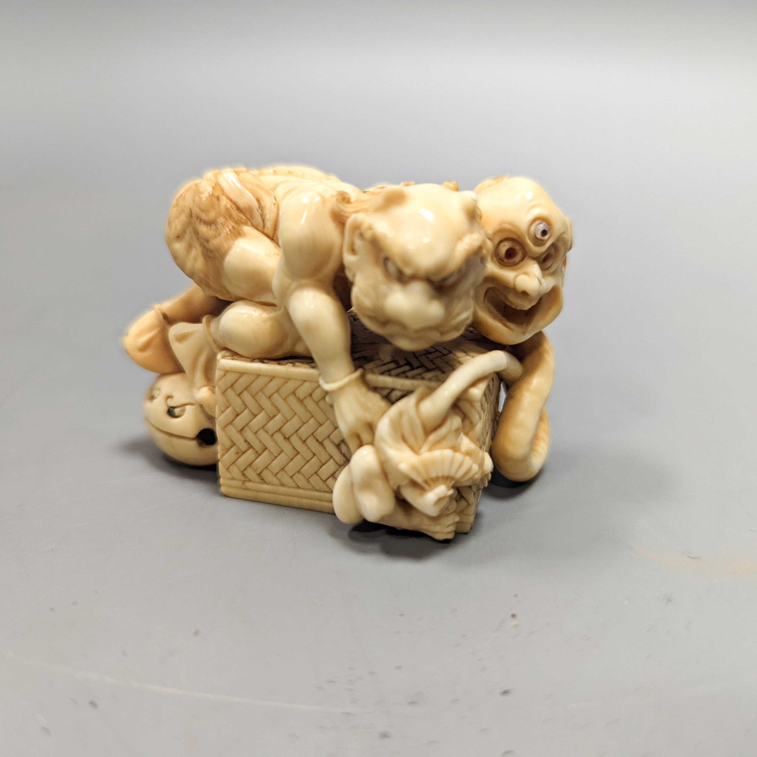 A Japanese ivory okimono of on a box, Meiji period, signed, 6 cms wide.